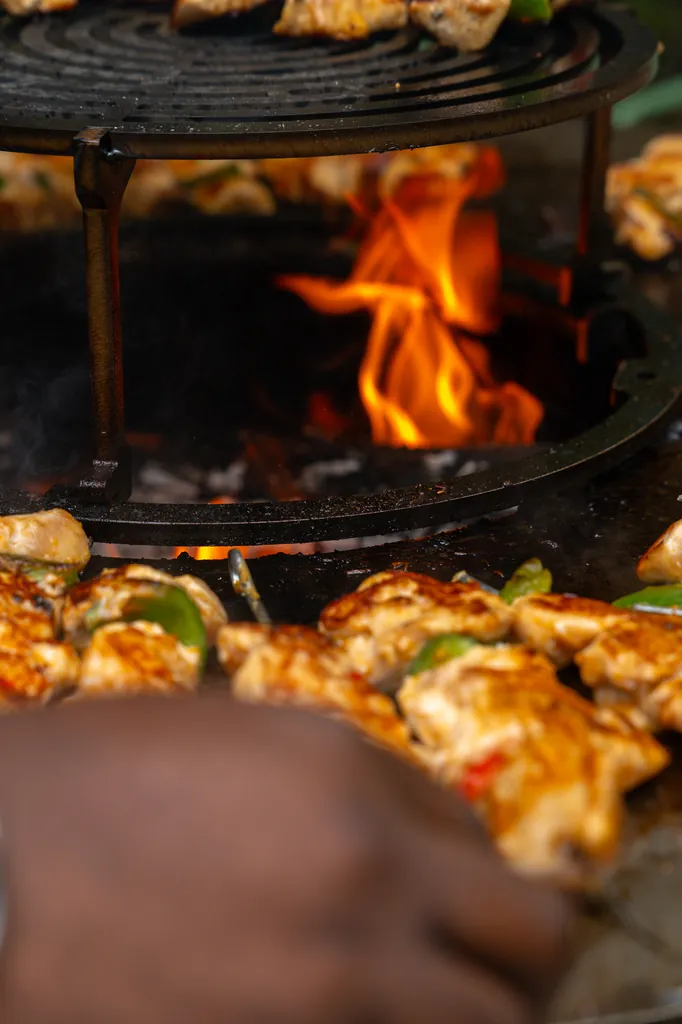 Open-fire grill with flames and skewers, food photography