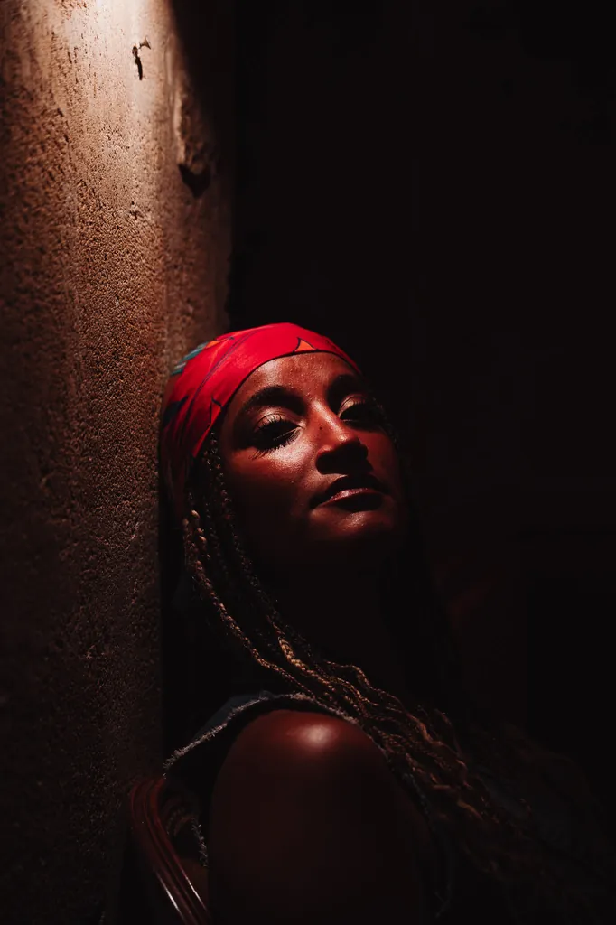 Portrait of a woman in a red bandana in low warm light